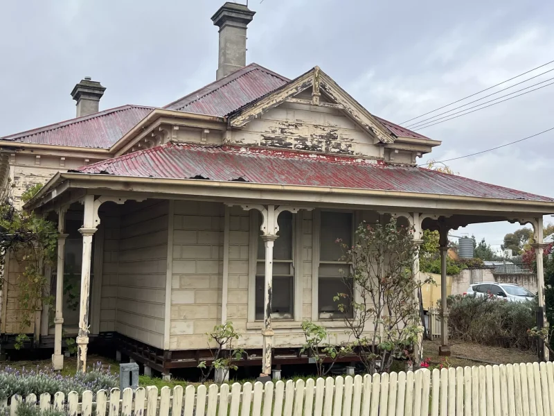 Close-up image of a house in Northcote before roof restoration, showing evident signs of aging and wear
