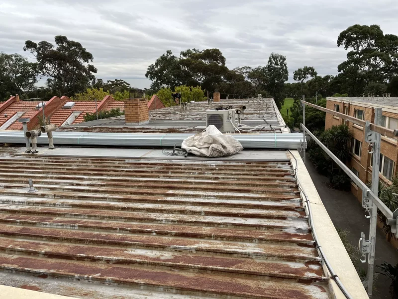 Close-up image of a roof in Unit Block Carlton showing signs of wear and damage before restoration with visible stains.